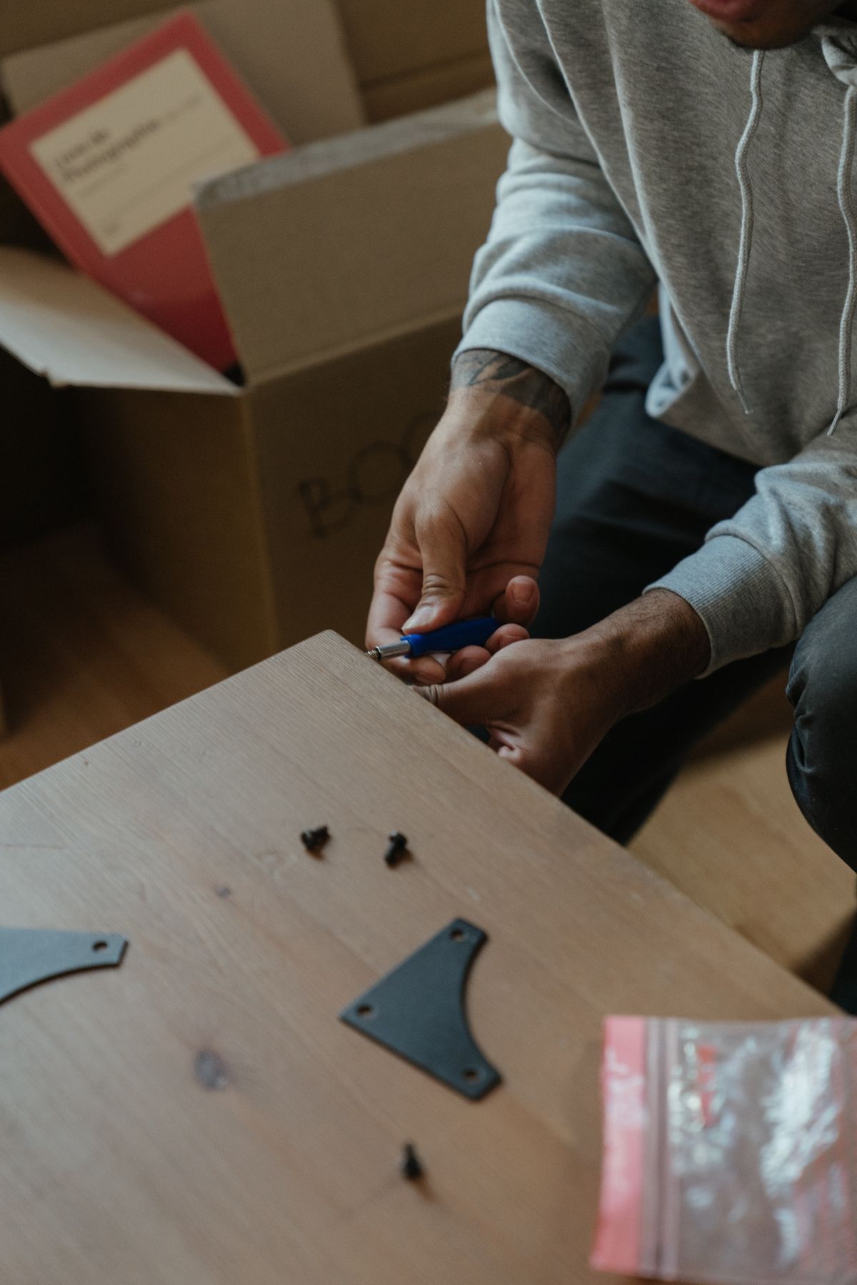 Handyman assembling a wooden table in a bright apartment