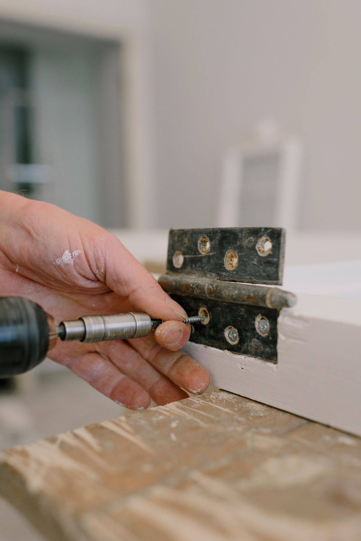 Handyman adjusting a cabinet hinge with a screwdriver
