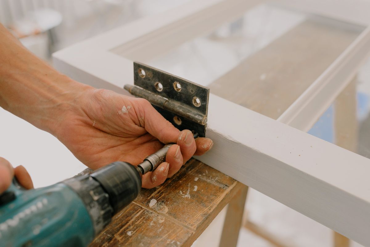 Handyman tightening a door handle during a home repair visit
